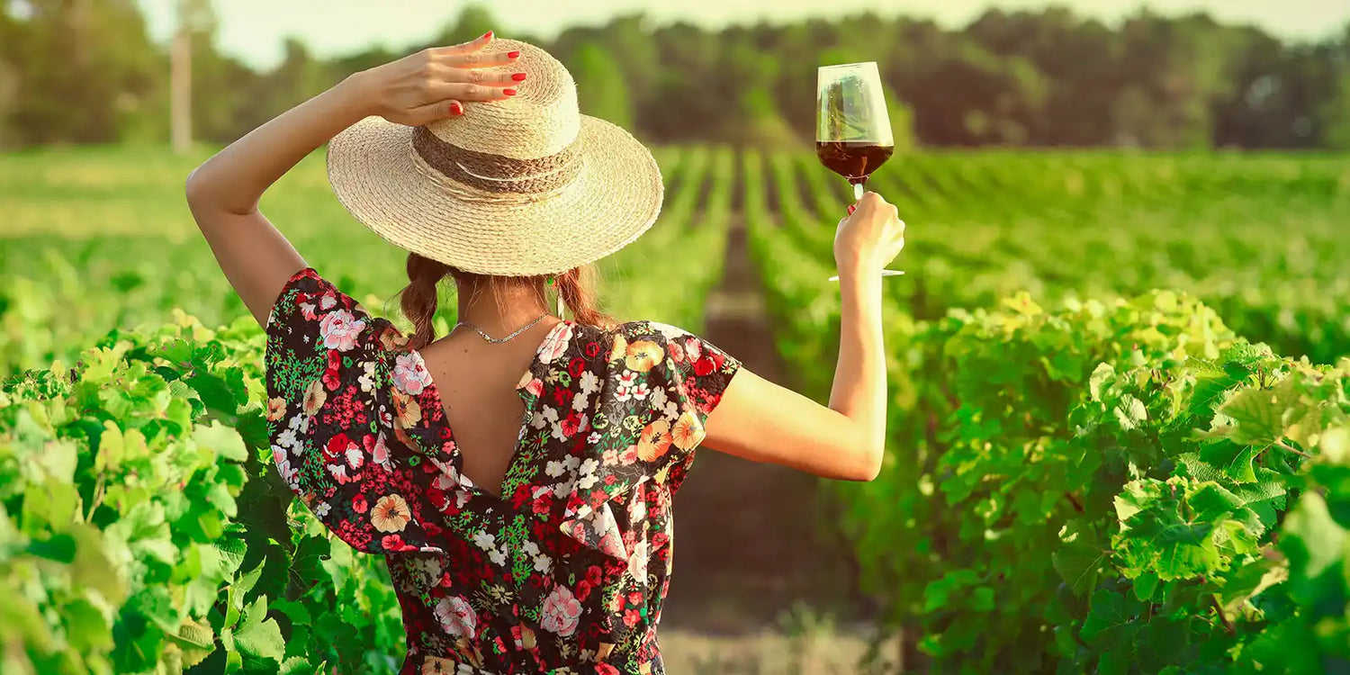 Woman in floral dress holding wine.